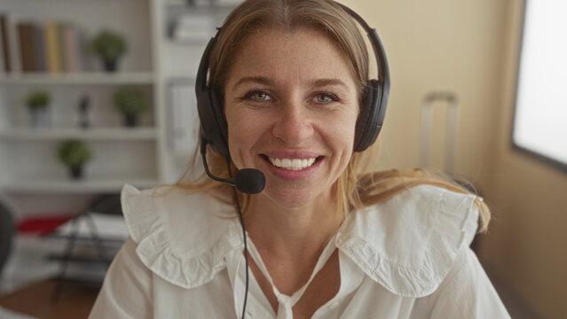 Woman with headset microphone smiling and speaking in an office building with headset mic visible; friendly remote support.