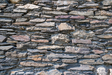 Photograph showcasing rugged limestone and granite wall with moss and shadow play for artistic projects