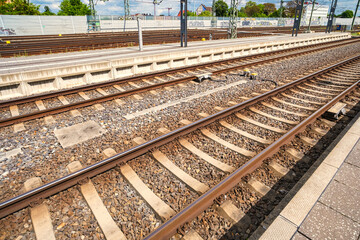 Naklejka premium railway detail closeup, tracks with sleepers and spikes, focused shot of railway components and ballast