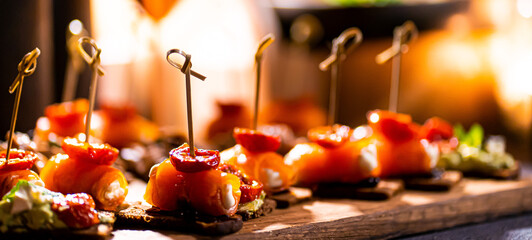 Pumpernickel bread sandwich snack with cured smoked salmon and fresh avocado served as close-up on a wooden cutting board
