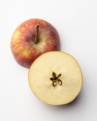 Fresh red apple sliced in half on white background, showing stem, seeds, and juicy interior. Perfect healthy fruit image for food, nutrition, and organic themes.