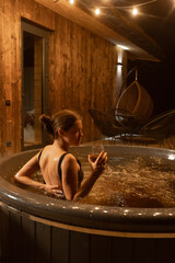 Relaxing evening in a hot tub under warm string lights