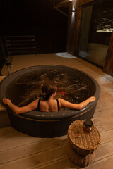 Relaxing evening soak in a wooden hot tub under the night sky