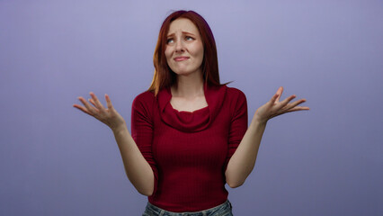 Woman expressing confusion against a purple wall, wearing a red sweater, with hands raised in a...