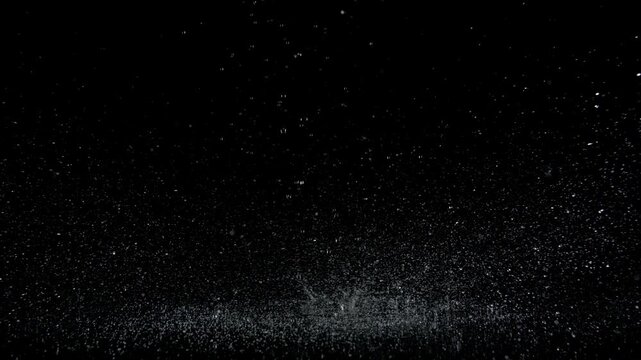 Super Slow Motion Shot of Real Raindrops Falling on a Surface, Isolated on Black, at 1000fps