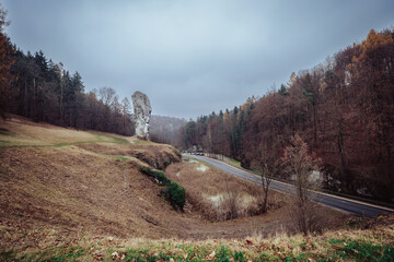 The beautiful Prądnik Valley. A winding road and river. A limestone rock formation known as Hercules' Club. The Krak&oacute;w-Częstochowa Upland. Poland. Autumn. Ojc&oacute;w National Park.