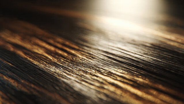 Close-up of a dark, textured surface, likely wood grain or brushed material, illuminated by a warm diagonal light creating striking reflections and shadows.