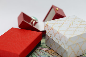 unique proposal/engagement ring and beautiful gift boxes on romanian leu banknotes (lei). concept of luxury, expenses, wealth, and buying gifts.