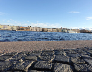 Old style big cobblestones on Neva river embankment in Saint-Petersburg in sunny day low point view 