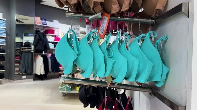 turquoise womens bras displayed on retail rack in clothing store