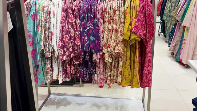 colorful printed kurtis displayed on retail clothing rack in fashion store