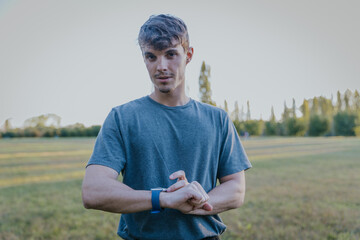 Fitness enthusiast checking smart watch after training in open air park