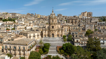 Obraz premium Aerial view of the facade of the Cathedral of San Giorgio, located in Modica, in the province of Ragusa, Sicily, Italy. It is a symbolic monument of Sicilian Baroque and the town's main attraction.