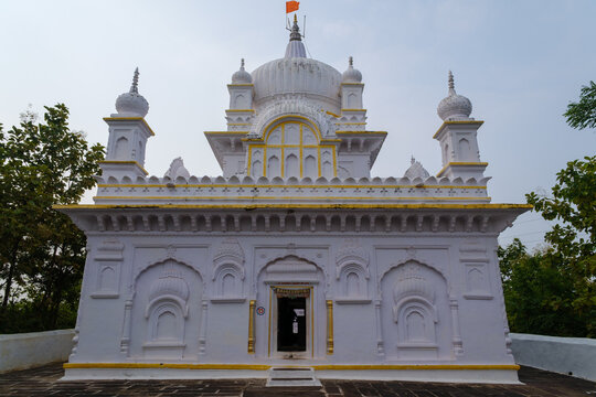 Elegant white Jain temple in Madhya Pradesh, featuring classic domes, intricate carvings, symmetrical fa&ccedil;ade, ornate entrance, and peaceful surroundings.