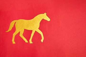 Golden horse silhouette on red background. Symbol of prosperity and strength in festive Chinese New Year 2026