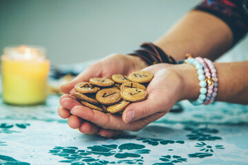 The fortune teller reads with runes in her hands. Selective focus.