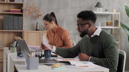 African american businessman analyzing documents at his desk - Powered by Adobe