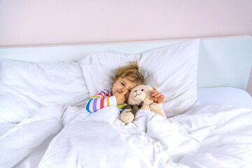 The child sleeps in the morning in bed. Selective focus.