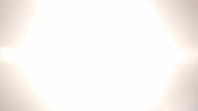 Bright light flare expanding into white screen