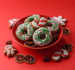 Christmas donuts or doughnuts, holiday winter sweets with sprinkles. Christmas donuts