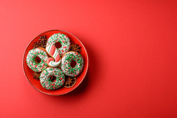 Christmas donuts or doughnuts, holiday winter sweets with sprinkles. Christmas donuts