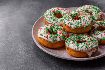 Christmas donuts or doughnuts, holiday winter sweets with sprinkles. Christmas donuts