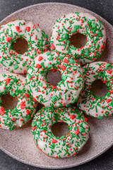 Christmas donuts or doughnuts, holiday winter sweets with sprinkles. Christmas donuts