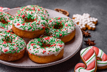 Christmas donuts or doughnuts, holiday winter sweets with sprinkles. Christmas donuts