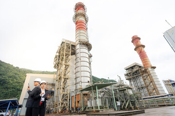 Asian male and female engineers monitor power plant performance and safety protocols, demonstrating strong responsibility, technical understanding, and teamwork required to manage industrial energy