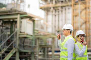 power plant and industrial plant, male and female engineers wearing reflective vests, design smart machinery and storage solutions that enhance international energy export efficiency.