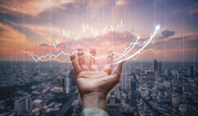 A hand reaches out with digital financial graphs illuminating the city skyline at sunset, symbolizing growth and success in market trends and investment opportunities. Scalp
