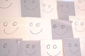multi colored faces showing happy emotions on several closely placed post-its. Concept showing inclusion and diversity. horizontal format,