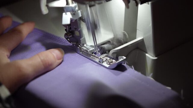 Learning serger basics at Home sewing edges of lavender fabric for a clean finish in this beginner's guide
