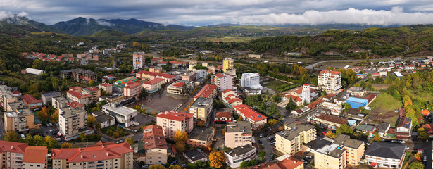 Aerial panorama of Rrëshen with its cathedral, autumn colours and surrounding hills across the Mirditë region of northern Albania.