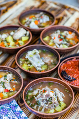 A man cooks traditional lamb soup in a cauldron over an outdoor fire in the Gagauzia autonomous region of Moldova. 