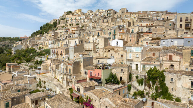 Aerial view of the roofs, houses and apartments, ideal for the concept of an Italian hilltop village nestled among the mountains. It's the historic center of Modica, province of Ragusa, Sicily, Italy. - Powered by Adobe