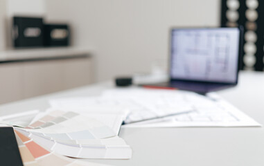 Interior design workspace with color palette and architectural plans
