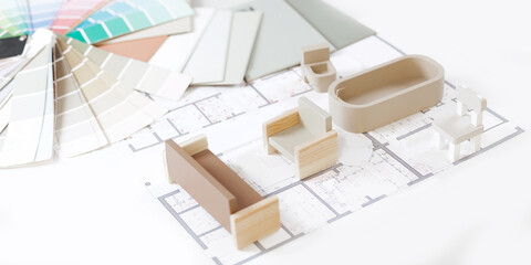 Interior design concept: architectural plans with miniature furniture and color swatches