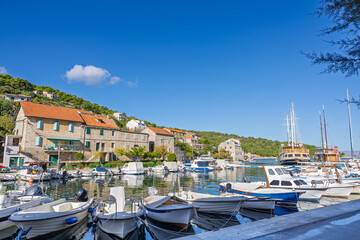 Obraz premium Coastal Harbor Village With Stone Buildings, Boats, And Calm Blue Water Reflections