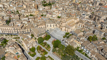 Aerial view of the Cathedral of San Giorgio, located in Modica, in the province of Ragusa, Sicily, Italy. This church is a symbol of Sicilian Baroque and the town's main attraction. It's a sunny day.
