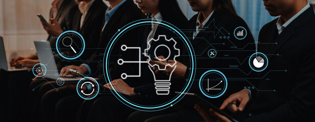 A diverse group of professionals focuses on technology and innovation in a modern office, engaging in discussions represented by digital icons and graphics. Trope