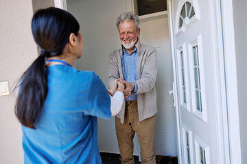 Doctor or nurse caregiver woman with senior man at home or nursing home, a caregiver standing on...