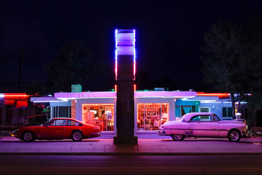 Tucumcari, New Mexico, USA. Famous Blue Swallow Motel on Route 66 at twilight with old cars parked in front and neon sign brightly lit. Property released 