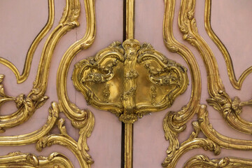 Vienna, Austria, Europe. .Antique Rococo door in pink with gold detailing