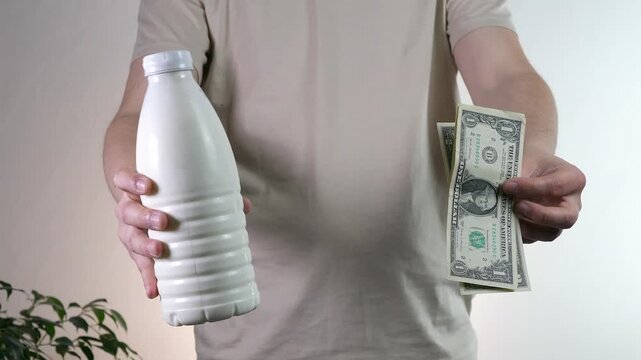 A minimalist composition comparing fundamental life essentials: nutrition and money. The shot of a milk bottle versus currency can symbolize investment in health, the value of wholesome food, or