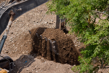 A yellow excavator at work &mdash; its power and precision carving the future foundation of a towering structure. A symbol of strength, progress, and the energy behind every great construction.