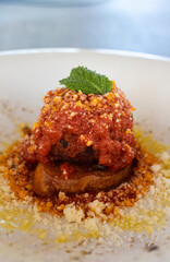 Meatball with marinara sauce parmesan mint garnish