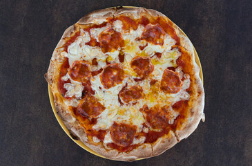 Pepperoni pizza on a dark background ready for eating