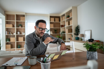 Businessman remotely working on laptop from home office