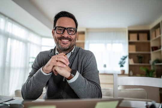 Smiling professional man working from his modern home office - Powered by Adobe